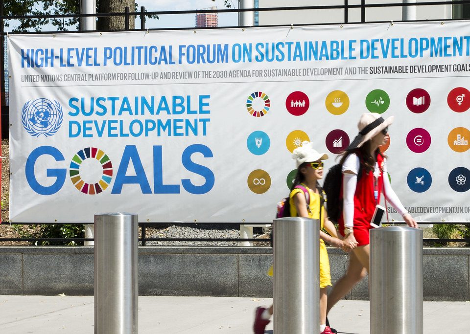 Poster for HLPF, 2 schoolgirls walk by in front of it