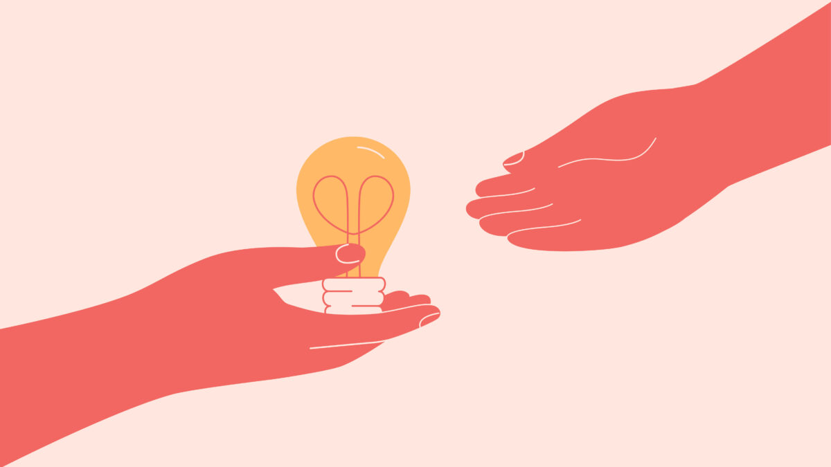 A hand passing a light bulb to another person's hand